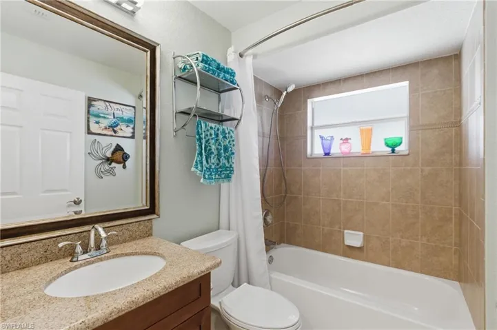 Full bath featuring vanity and shower / bathtub combination with curtain
