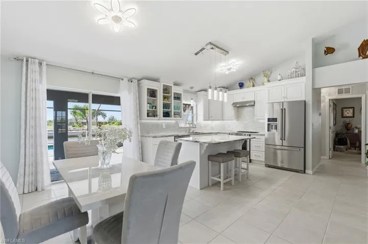 Dining area featuring lofted ceiling and light tile patterned floors