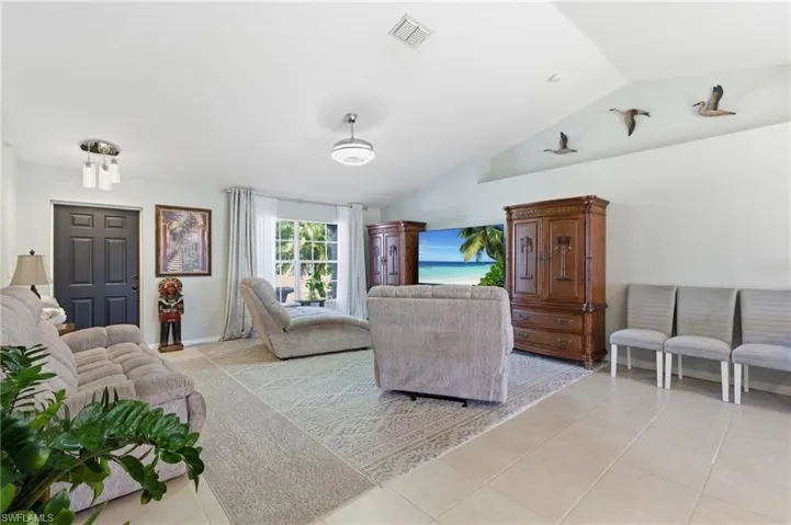 Living area featuring vaulted ceiling and light tile patterned floors