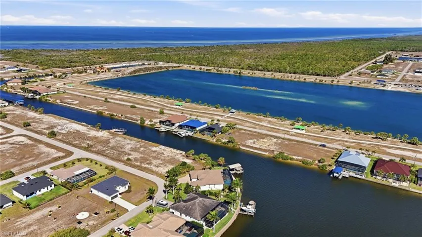 Aerial overview of property's location featuring a nearby body of water and nearby suburban area