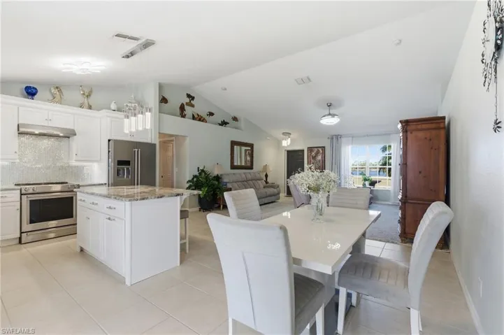 Dining space featuring light tile patterned flooring and a high ceiling