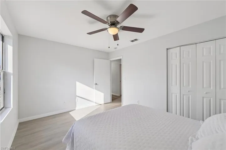 Bedroom with wood finished floors, a ceiling fan, and a closet