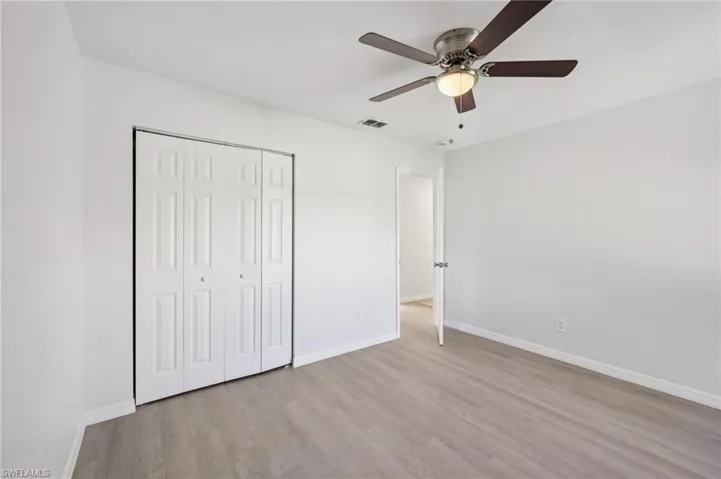 Unfurnished bedroom featuring light wood-style floors, a ceiling fan, and a closet