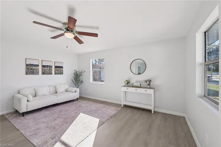 Living area with light wood-style flooring and ceiling fan