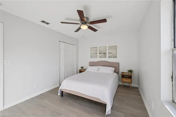 Bedroom with wood finished floors, a ceiling fan, and a closet