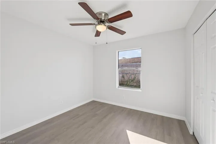 Unfurnished bedroom with a closet, wood finished floors, and a ceiling fan