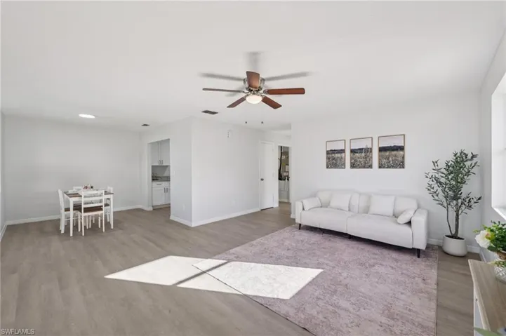 Living area featuring light wood-type flooring and ceiling fan