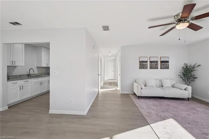Living area with a ceiling fan and light wood-style floors