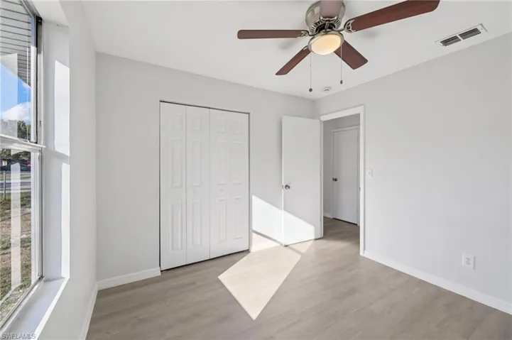 Unfurnished bedroom featuring multiple windows, light wood-style floors, and ceiling fan