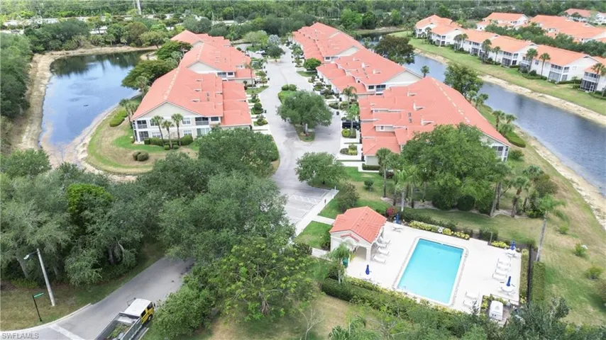 Aerial perspective of suburban area with a large body of water and a pool
