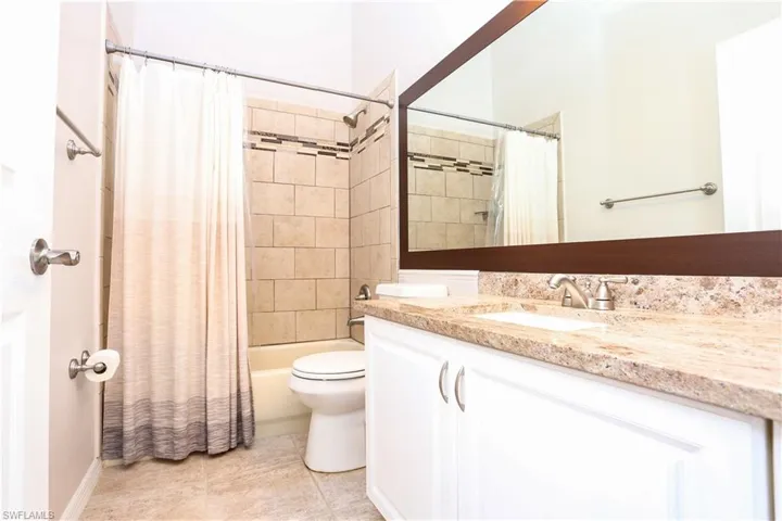 Full bathroom with vanity, toilet, shower / bath combo, and tile patterned floors