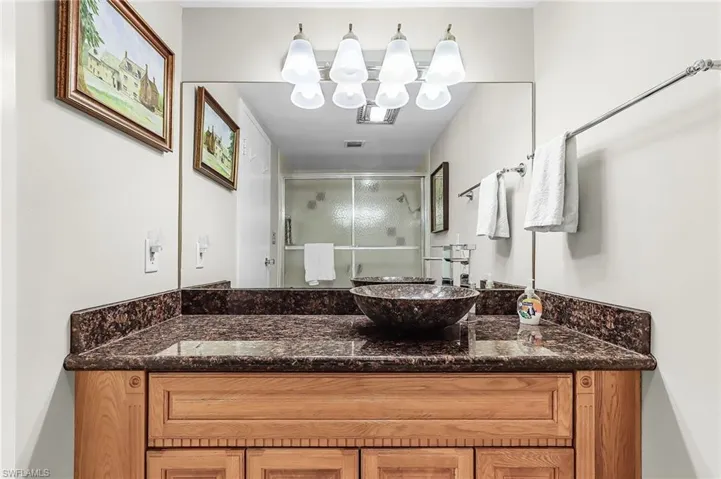Bathroom featuring a shower stall and vanity