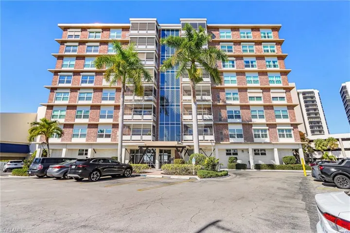 View of apartment building / complex with uncovered parking