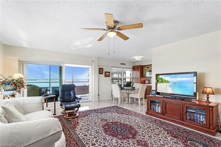 Living area with ceiling fan and a textured ceiling