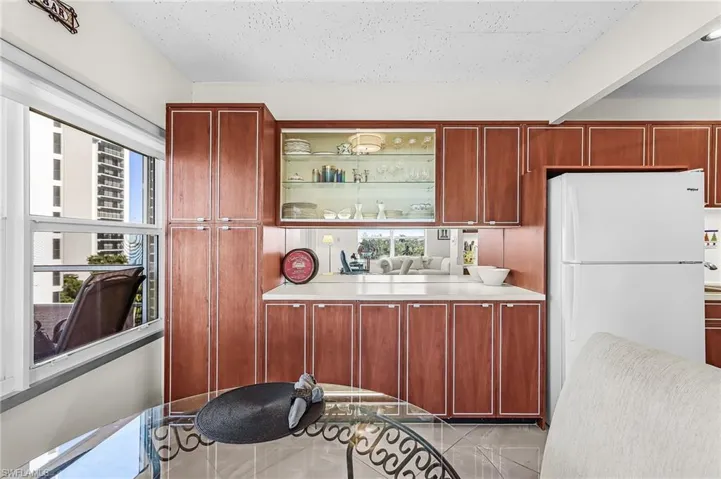 Kitchen featuring freestanding refrigerator, light countertops, open shelves, and a textured ceiling
