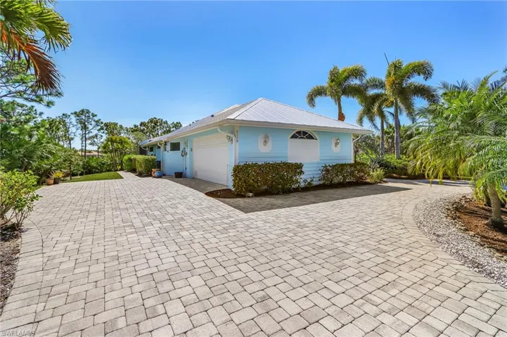 View of side of property featuring decorative driveway and an attached garage