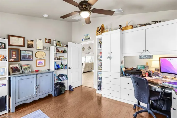 Office featuring light wood-style flooring, ceiling fan, and vaulted ceiling