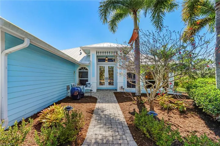 Back of property featuring french doors and a metal roof
