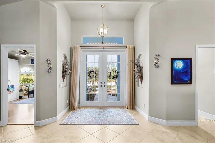 Foyer entrance with french doors, a high ceiling, and a ceiling fan