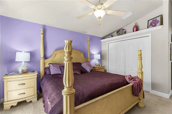 Bedroom featuring light carpet, a closet, vaulted ceiling, and a ceiling fan