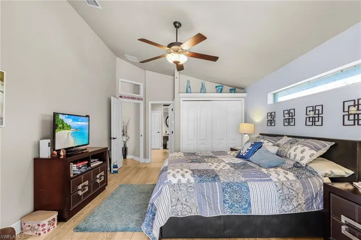 Bedroom featuring light wood-type flooring, a closet, vaulted ceiling, and ceiling fan
