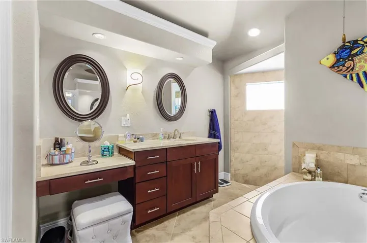 Full bath featuring vanity, a garden tub, a walk in shower, recessed lighting, and light tile patterned floors