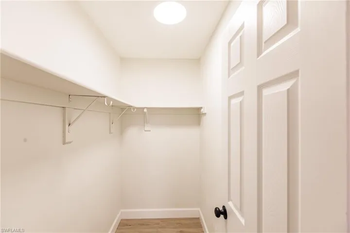 Spacious closet with hardwood / wood-style flooring