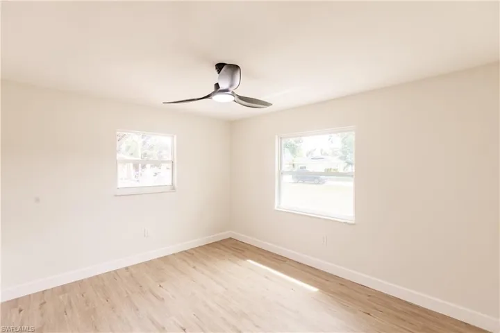 Empty room featuring ceiling fan, light hardwood / wood-style floors, and a wealth of natural light