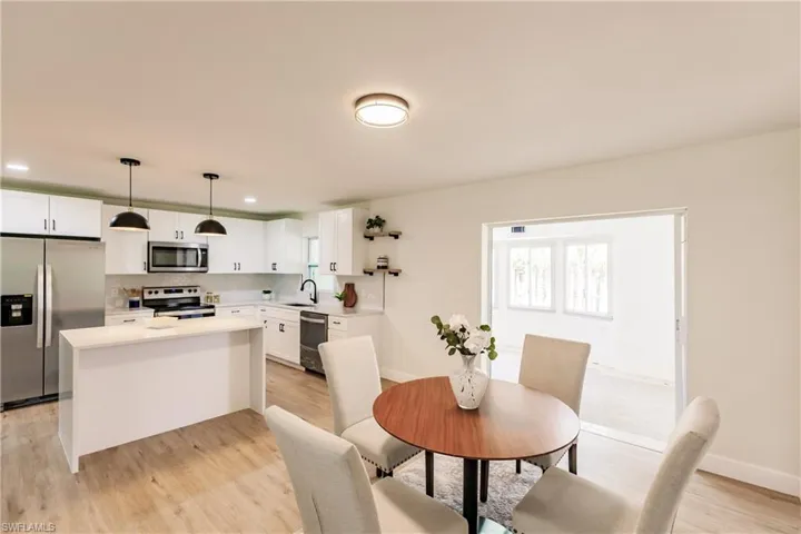 Dining area with sink and light wood-type flooring