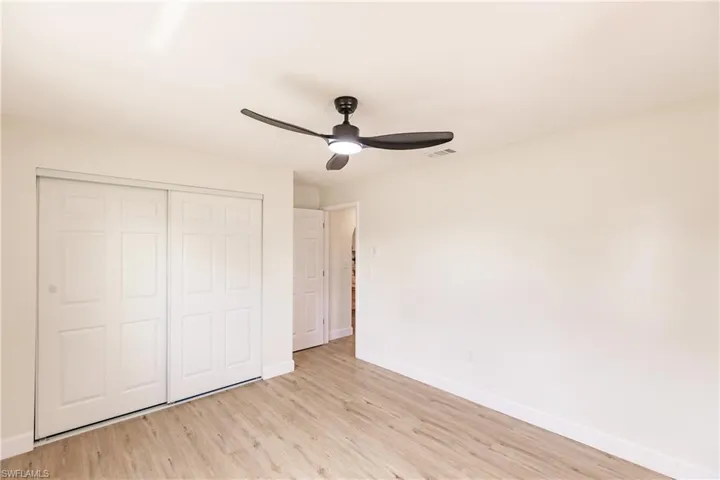 Unfurnished bedroom featuring ceiling fan, a closet, and light hardwood / wood-style flooring
