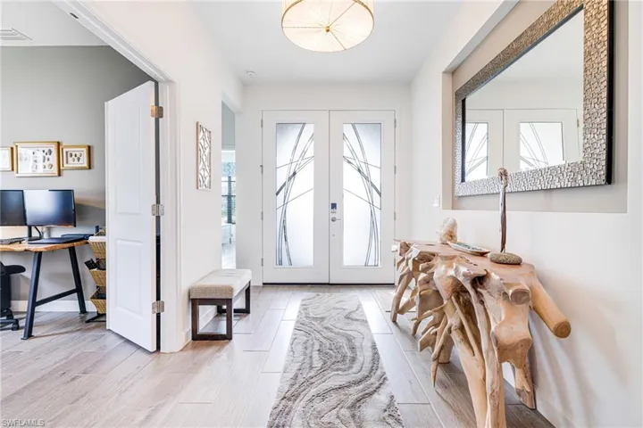 Entrance foyer featuring french doors, visible vents, light wood-style flooring, and baseboards