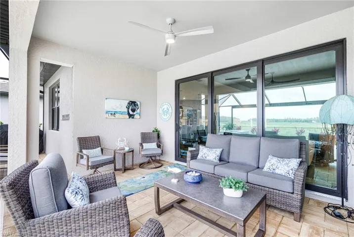 Living room featuring a ceiling fan, a sunroom, and a textured wall
