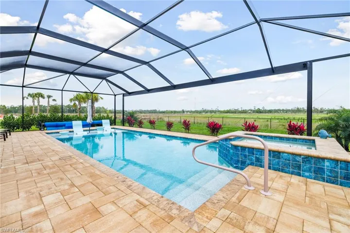 Outdoor pool with a lanai, a patio area, and an in ground hot tub
