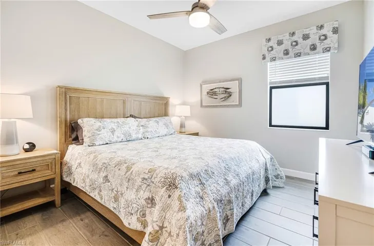 Bedroom with light wood-style floors, ceiling fan, and baseboards