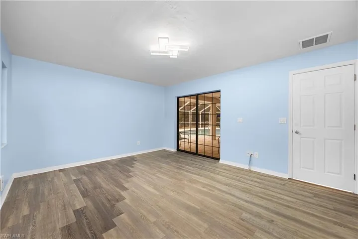 Unfurnished room with wood finished floors and baseboards