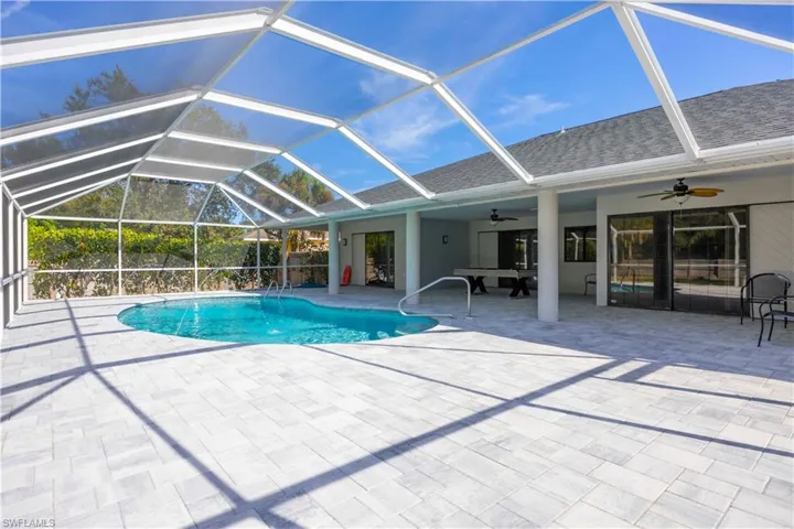 Swimming pool featuring a lanai, a sunroom, and a patio