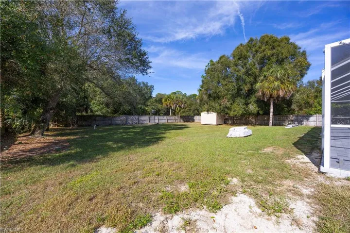 Fenced backyard featuring a storage shed