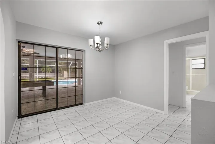Unfurnished room featuring a chandelier and plenty of natural light