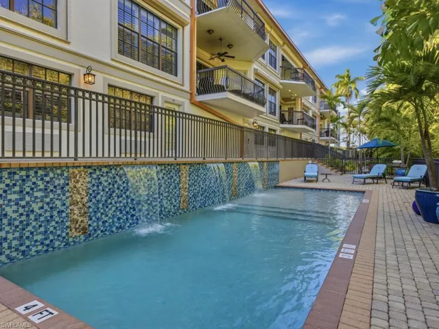 Community pool featuring a serene waterfall