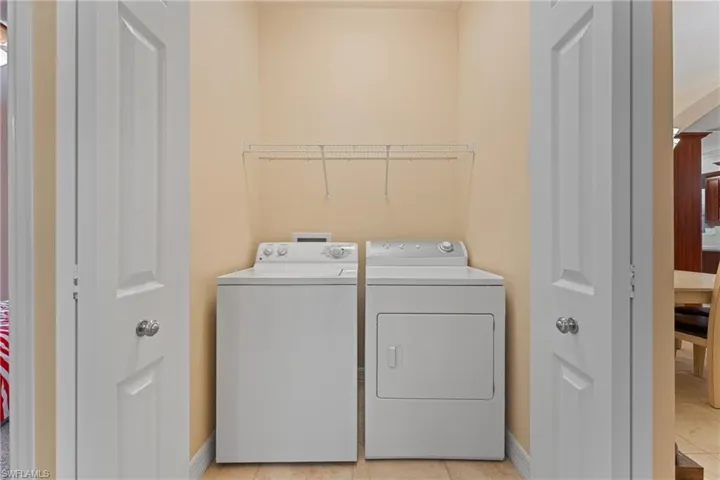 Laundry room featuring light tile patterned floors and washer and dryer