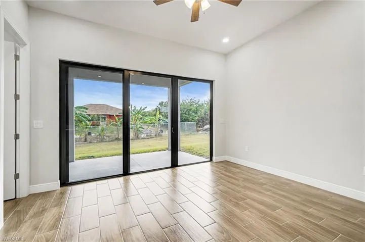 Empty room with wood finish floors, a ceiling fan, and recessed lighting