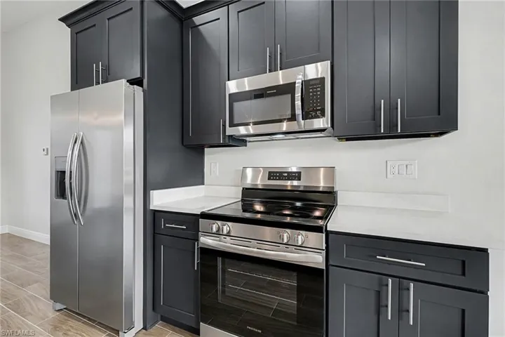 Kitchen featuring stainless steel appliances and light stone countertops
