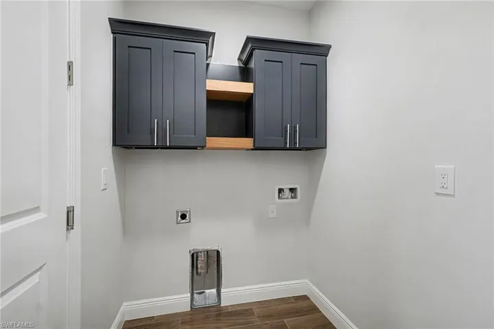 Laundry room with cabinet space, wood finish floors, electric dryer hookup, and hookup for a washing machine