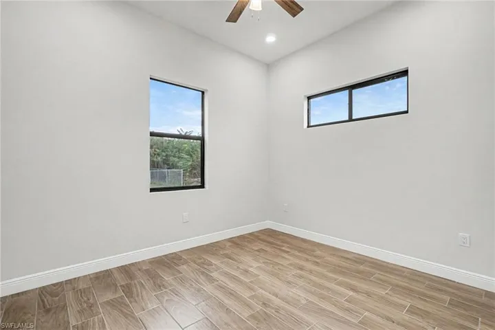 Spare room with wood finish floors, a ceiling fan, and recessed lighting