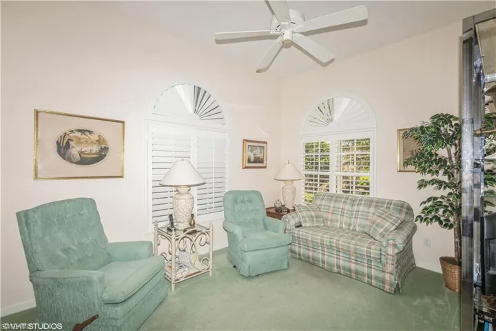 Living area featuring carpet and ceiling fan
