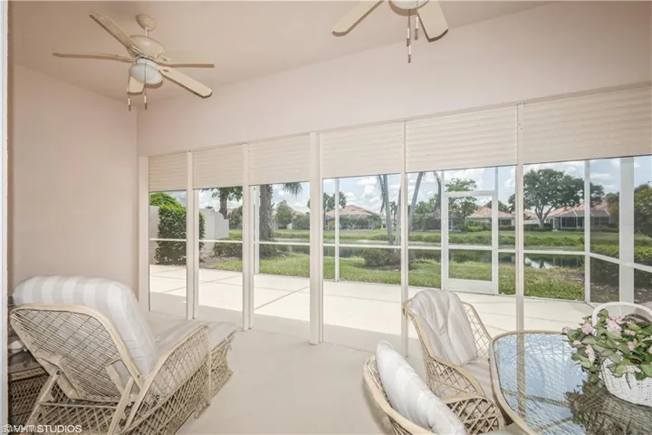 Sunroom / solarium with ceiling fan and a water view
