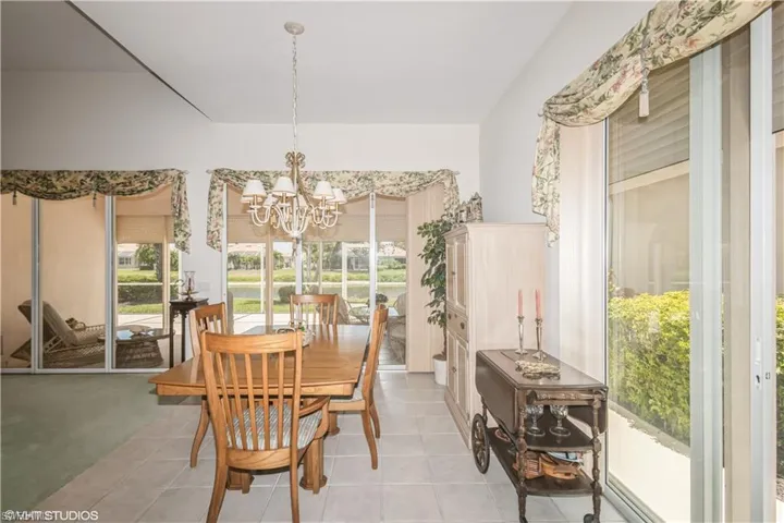 Dining area featuring light colored carpet and a chandelier