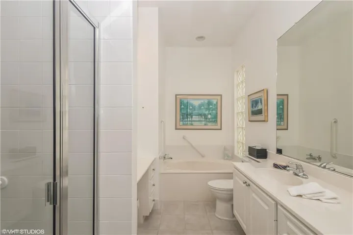 Full bathroom with vanity, toilet, tile floors, and plus walk in shower