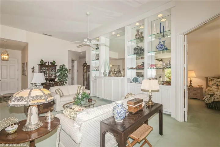 Carpeted living room with ceiling fan