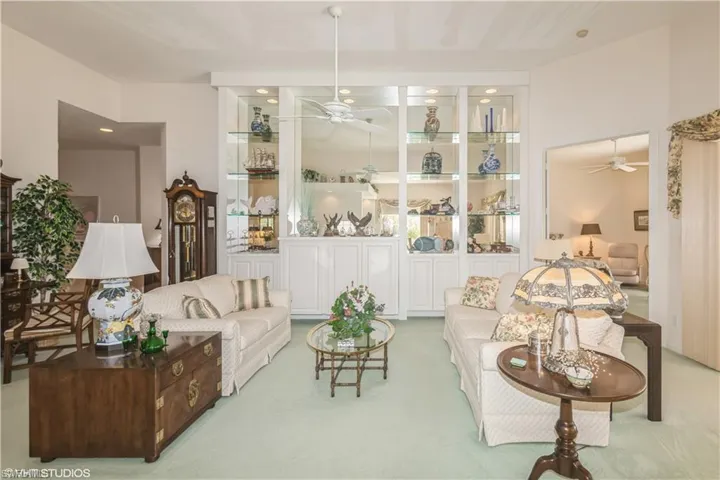 Carpeted living room with ceiling fan